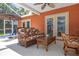 The screened-in patio includes wicker furniture, seating, and access to the pool at 460 Meravan Dr, Palm Harbor, FL 34683