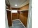 Walk-in closet featuring built-in shelves and wood-paneled walls at 4851 W Gandy Blvd # B10L30, Tampa, FL 33611