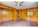 Spacious bedroom featuring wood paneling, tile floors, ceiling fan, and closet at 5290 Cyril Dr, Dade City, FL 33523
