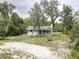 Charming single-story home featuring a quaint front porch and surrounded by lush landscaping at 5290 Cyril Dr, Dade City, FL 33523