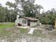 Single story house with mature trees and overgrown yard at 5290 Cyril Dr, Dade City, FL 33523