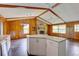 Kitchen and living area features wood beams, brick fireplace, and breakfast bar at 5290 Cyril Dr, Dade City, FL 33523