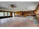 Large living room with wood paneled wall and partial kitchen space at 5290 Cyril Dr, Dade City, FL 33523