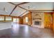 Spacious living room with brick fireplace, wood paneling, ceiling fans, and tile floors at 5290 Cyril Dr, Dade City, FL 33523