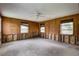 Living room featuring wood paneling and windows providing natural light at 5290 Cyril Dr, Dade City, FL 33523