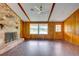 The living room shows tiled floors, wood paneled walls, ceiling fan, fireplace, and windows at 5290 Cyril Dr, Dade City, FL 33523