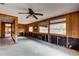Living room featuring wood paneling and windows providing natural light at 5290 Cyril Dr, Dade City, FL 33523