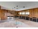 Large room with wood paneled walls and partial kitchen space at 5290 Cyril Dr, Dade City, FL 33523