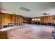 Spacious living room and damaged kitchen area with exposed framing at 5290 Cyril Dr, Dade City, FL 33523