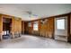 Spacious room featuring wood paneling, ceiling fan, and natural light perfect for renovation at 5290 Cyril Dr, Dade City, FL 33523