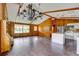 Spacious living room features wood paneled walls, wood beams, and access to kitchen with breakfast bar at 5290 Cyril Dr, Dade City, FL 33523
