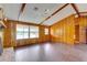 Bright living room featuring wood paneling, beams, fireplace, ceiling fan and tile floors at 5290 Cyril Dr, Dade City, FL 33523