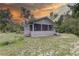 View of rear of the house with screened in porch and stairs to the yard at 5290 Cyril Dr, Dade City, FL 33523