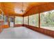 Enclosed sunroom featuring wood paneled walls, large windows, and laundry area at 5290 Cyril Dr, Dade City, FL 33523