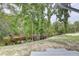 Backyard featuring a waterfront view, sandy shoreline, and mature trees at 5290 Cyril Dr, Dade City, FL 33523