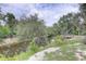 Backyard featuring a waterfront view and sandy shoreline with mature trees at 5290 Cyril Dr, Dade City, FL 33523