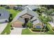 Aerial view of the well-maintained property with a two-car garage, lush landscaping, and mature palm trees at 5303 Cottonwood Tree Cir, Valrico, FL 33596