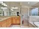 A modern bathroom featuring dual sinks, granite countertops, a tiled shower, and a separate soaking tub at 5303 Cottonwood Tree Cir, Valrico, FL 33596