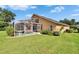 Backyard view of this home featuring a screened-in pool, outdoor patio, and expansive green lawn at 5303 Cottonwood Tree Cir, Valrico, FL 33596