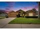 Charming single-Gathering home showcasing lush landscaping and a two-car garage, set against a colorful twilight sky at 5303 Cottonwood Tree Cir, Valrico, FL 33596