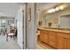 Hallway view into bathroom with double vanity, granite countertops and wood cabinets at 5303 Cottonwood Tree Cir, Valrico, FL 33596