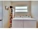 Laundry room with a washer, dryer, shelving, and a window for natural light at 5303 Cottonwood Tree Cir, Valrico, FL 33596