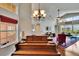 Spacious living area with a grand piano, high ceilings, and access to the outdoor pool area at 5303 Cottonwood Tree Cir, Valrico, FL 33596