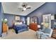 A beautifully decorated main bedroom suite featuring a plush bed, ceiling fan, a window, and a comfortable armchair at 5303 Cottonwood Tree Cir, Valrico, FL 33596