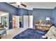 A bedroom with a dark blue painted wall, white trim, and access to a porch through sliding glass doors at 5303 Cottonwood Tree Cir, Valrico, FL 33596