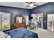 A bedroom with a dark blue painted wall, white trim, and access to a porch through sliding glass doors at 5303 Cottonwood Tree Cir, Valrico, FL 33596