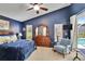 A beautifully decorated main bedroom suite featuring a plush bed, ceiling fan, a window, and a comfortable armchair at 5303 Cottonwood Tree Cir, Valrico, FL 33596