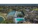 Aerial view of tennis courts and a pool surrounded by lush greenery at 5303 Cottonwood Tree Cir, Valrico, FL 33596