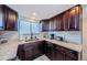 Well-lit kitchen featuring dark wood cabinets, granite countertops, and tile backsplash at 6009 Sea Ranch Dr # 306, Hudson, FL 34667