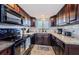 Lovely kitchen boasting dark wood cabinets, tile backsplash, granite countertops, and modern appliances at 6009 Sea Ranch Dr # 306, Hudson, FL 34667