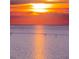 A vibrant sunset over the ocean with paddleboarders enjoying the tranquil waters at 6009 Sea Ranch Dr # 306, Hudson, FL 34667