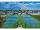 Overhead view of well-maintained tennis courts near beautiful waterfront homes and clear blue skies at 6009 Sea Ranch Dr # 306, Hudson, FL 34667
