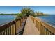 Wooden walkway leads to a private wooded island surrounded by serene waters at 6009 Sea Ranch Dr # 306, Hudson, FL 34667