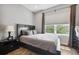 Relaxing bedroom with a comfortable bed, side table, window with natural light, and wood floor at 6049 Moorings S Dr, St Petersburg, FL 33712