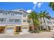 Charming townhome exterior featuring attached garages, multi-story design, and tropical landscaping at 6049 Moorings S Dr, St Petersburg, FL 33712