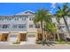 Charming multi-story townhome featuring a private garage, covered entry, and tropical landscaping at 6049 Moorings S Dr, St Petersburg, FL 33712