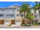 Charming townhomes boast a bright exterior, complemented by lush palm trees and beautiful landscaping at 6049 Moorings S Dr, St Petersburg, FL 33712