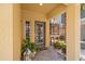 Inviting covered entry with a gray front door, complemented by colorful plants and tiled flooring at 6049 Moorings S Dr, St Petersburg, FL 33712