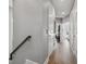Bright hallway featuring hardwood flooring, neutral paint, and doors leading to various rooms at 6049 Moorings S Dr, St Petersburg, FL 33712