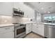 The kitchen features bright white cabinets, stainless steel appliances, and a tiled backsplash at 6049 Moorings S Dr, St Petersburg, FL 33712