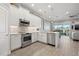 Kitchen featuring white cabinets with stainless steel appliances, a breakfast bar and tile backsplash at 6049 Moorings S Dr, St Petersburg, FL 33712
