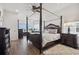 This main bedroom boasts a four-poster bed, hardwood floors, and water views at 6049 Moorings S Dr, St Petersburg, FL 33712