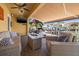Covered outdoor patio with a cozy fire pit and relaxing seating overlooking the waterfront at 6049 Moorings S Dr, St Petersburg, FL 33712