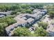 An aerial view shows the apartment buildings with a lush canopy of trees and parking at 8517 Island Breeze Ln # 207, Temple Terrace, FL 33637