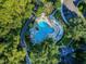 A calming aerial view of the community pool area surrounded by parking and an abundance of green trees at 8517 Island Breeze Ln # 207, Temple Terrace, FL 33637