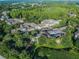 An aerial view of the apartments shows lush landscaping with mature trees and a pond nearby at 8517 Island Breeze Ln # 207, Temple Terrace, FL 33637